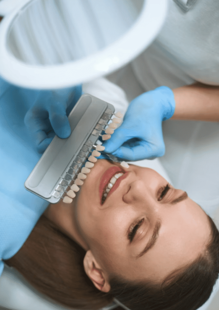 Smiling young woman lying in a dental chair during a professional teeth whitening consultation with a dentist in Beckenham